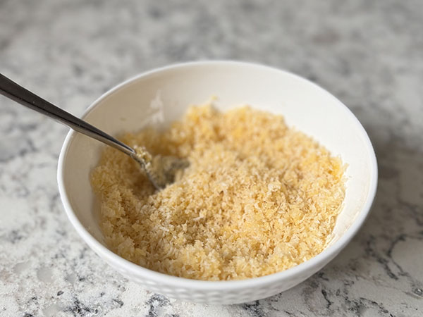 Panko breadcrumbs in a bowl mixed with melted ghee.