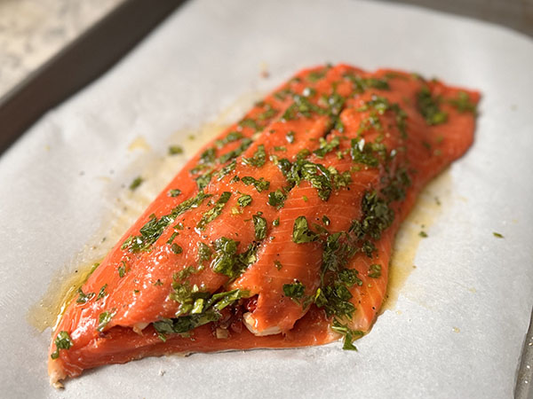 Филе лосося с начинкой, смазанное смесью масла гхи и петрушки.