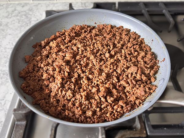 Taco seasoned cooked ground beef in a skillet.