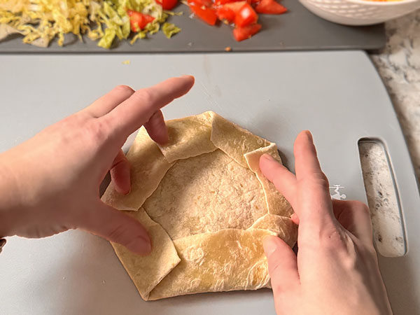 Photo instruction on how to fold the edges of the tortilla to create a beautiful wrap.