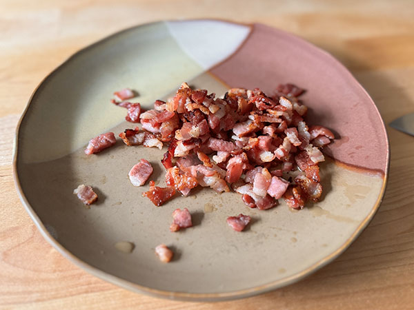 Cooked bacon bites on a plate.