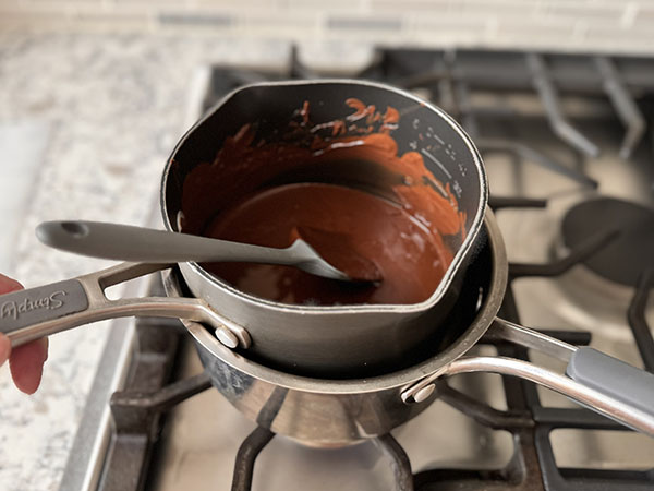 Melted chocolate in a double boiler on the stovetop.