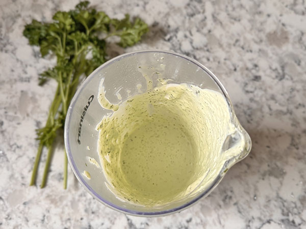 Sour cream parsley sauce in a blender cup.
