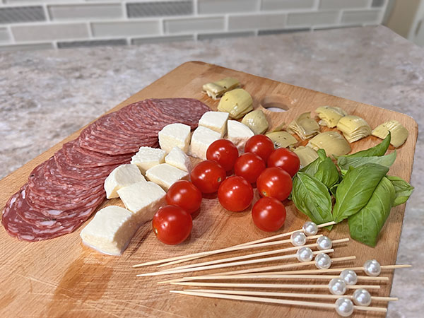 Ingredients for Italian antipasto caprese skewers with salami and artichokes.