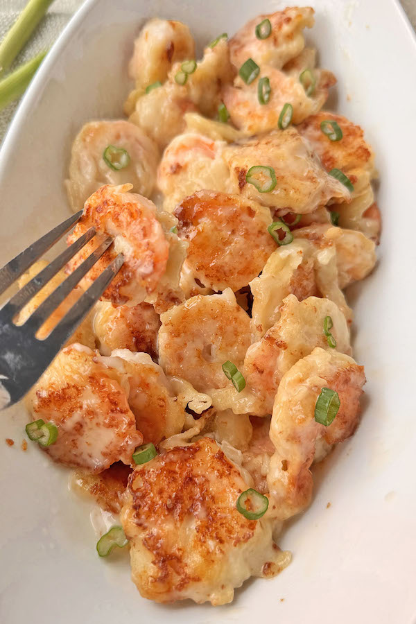 Chinese style sweet creamy coconut shrimp in a serving bowl, garnished with chopped green onions.