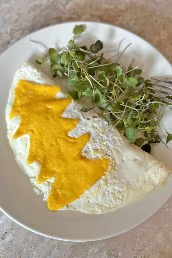 Fun and festive Christmas tree omelette served with microgreens.