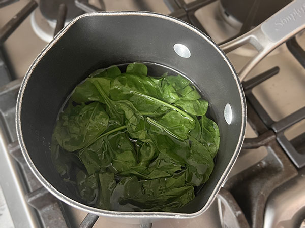 Cooking spinach to make natural green coloring.
