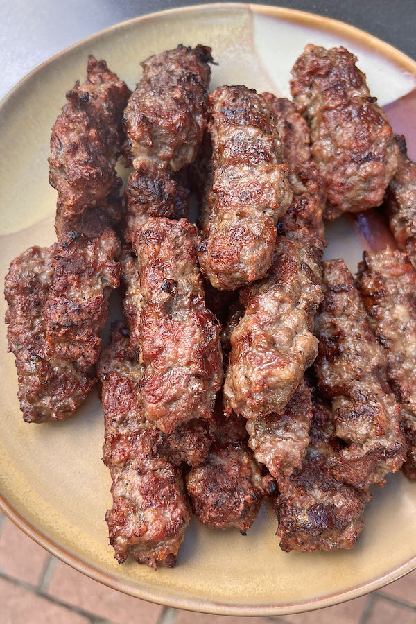 Grilled Serbian Cevapi sausages served on a plate.