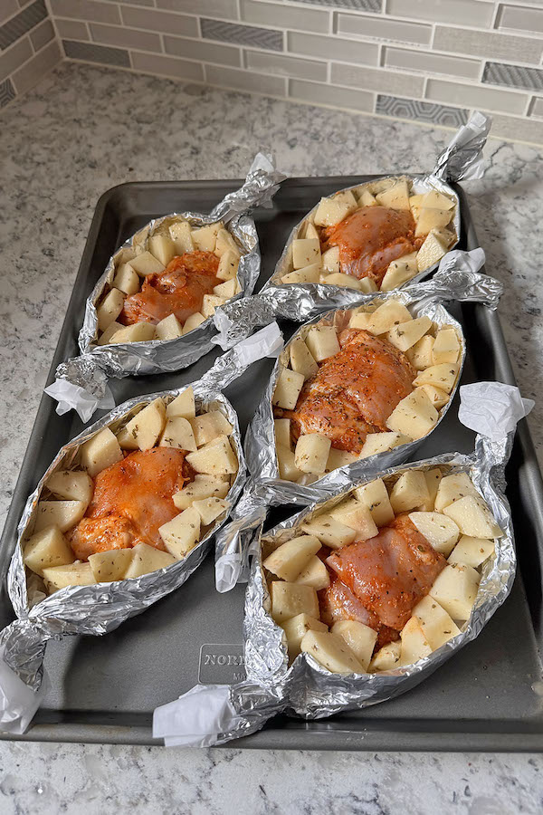 Картофель и курица выложенные в лодочках для запекания, готовы к духовке.