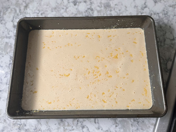 Dutch Baby Pancake batter poured in the prepared baking dish.