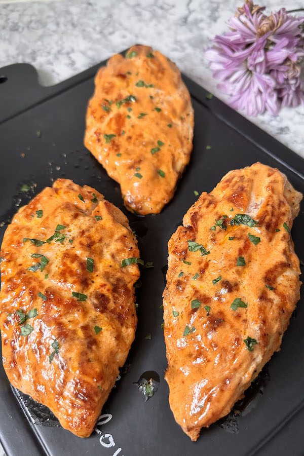 Pan Fried Chicken Breasts brushed with a Quick Dipping Sauce on a serving board.