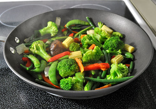 Coscto Kirkland Stir Fry vegetables mix cooking on stove top in a large pan.