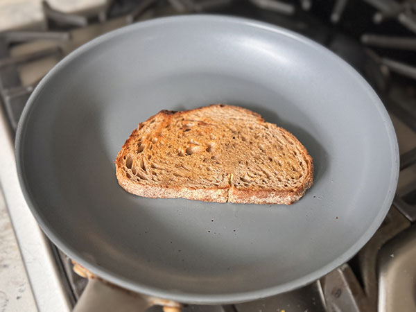 Slice of bread toasting in a skillet.