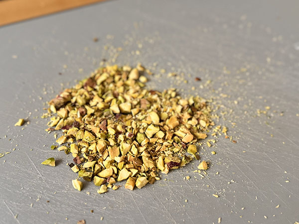 Finely chopped pistachios on a cutting board.